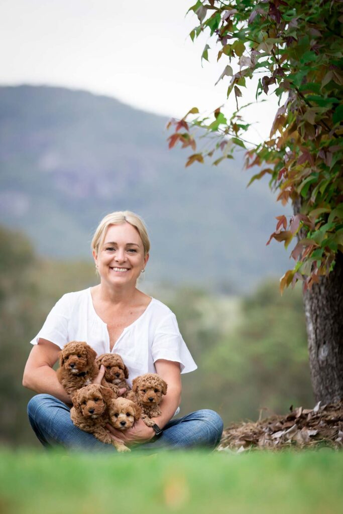 Sarah Orchard owner of Waterhill Cavoodles. Ditting on the green grass on her property in South east Queensland